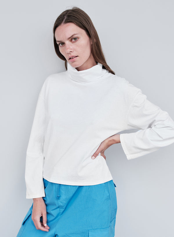 White jersey cowl neck hand on hip