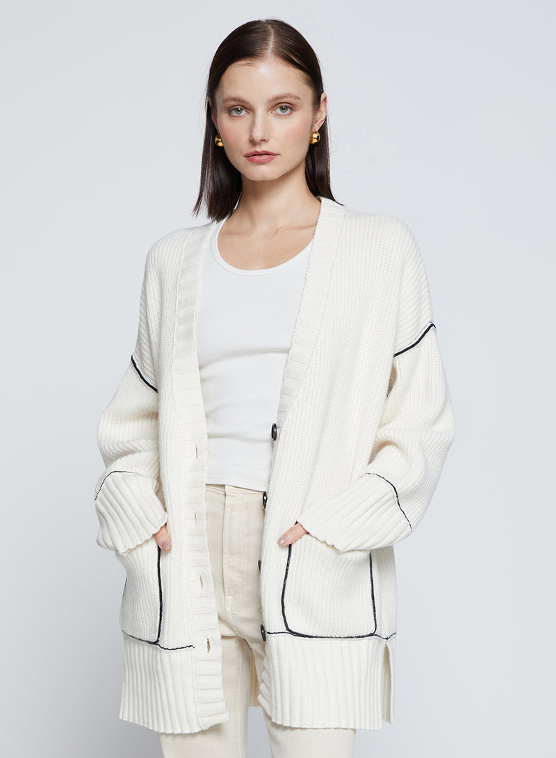 The Billy Cardigan Sweater in Cream-model has her hands in her pocket