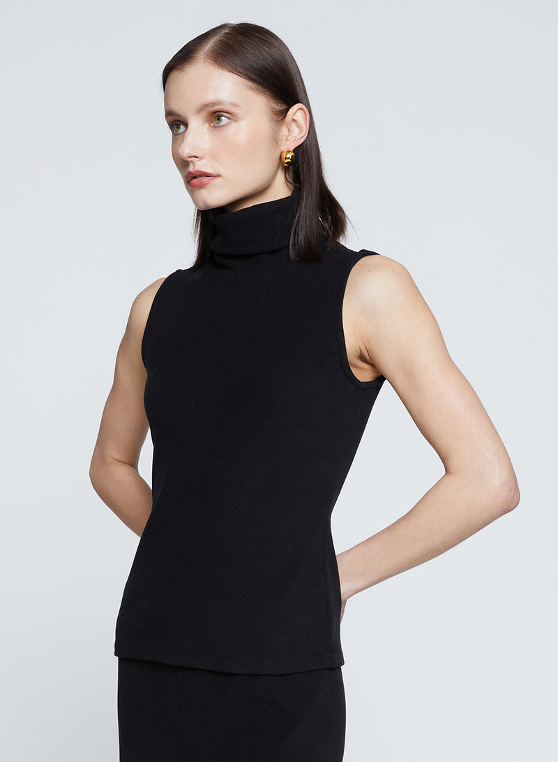 Honeyluxe Flat Back Rib Sleeveless Turtleneck in Black-model has her hands behind her back 