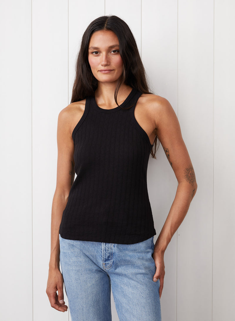 Double Faced Pointelle Tank in Black - front view with the hand on the pant 