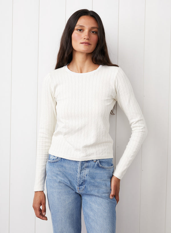 Double Faced Pointelle Long Sleeve Top in Cream - front view with hand on her pants