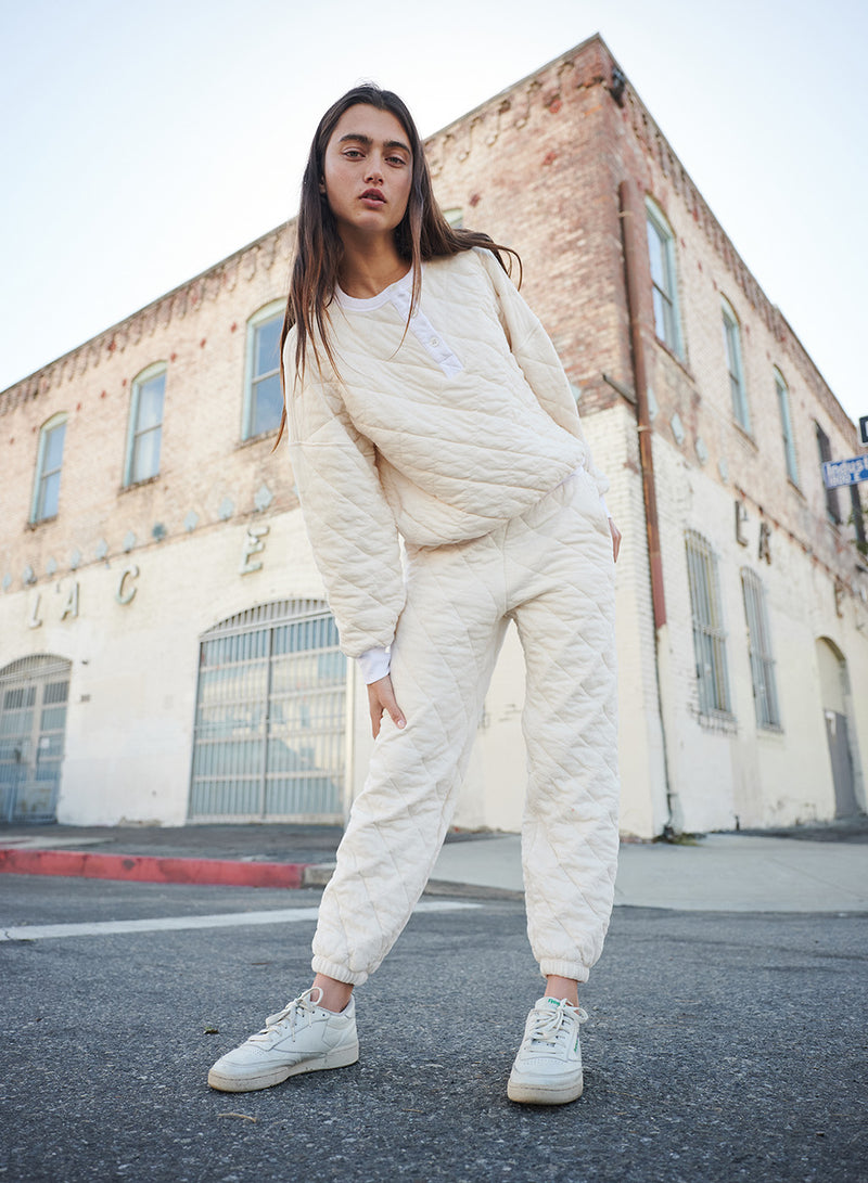 Quilted Oversized Henley Pullover in Cream-model with bent leg